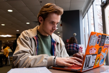 Male SIUC student working on customized laptop